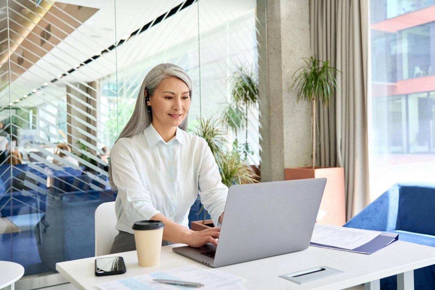 Compliance officer in the UAE reviewing beneficial ownership and PEP screening results on a laptop
